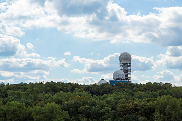 Teufelsberg Berlin, Germany - August 17, 2016: View from the Drachenberg to the former flight monitoring and communications intercept stations of the United States military at the Teufelsberg. The Teufelsberg is located at the Grunewald and is the second highest elevation of Berlin city area. After leaving of the US forces the buildings were used as flight control station during from 1991 until 1999. grunewald berlin stock pictures, royalty-free photos & images