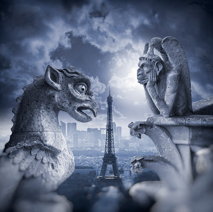 Gargoyle figur on Notre Dame looking towards Eiffel Tower at night