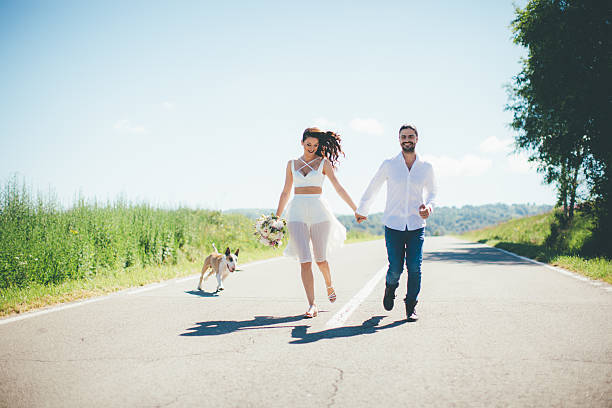 istock Bride and groom having fun with their dog 590141306