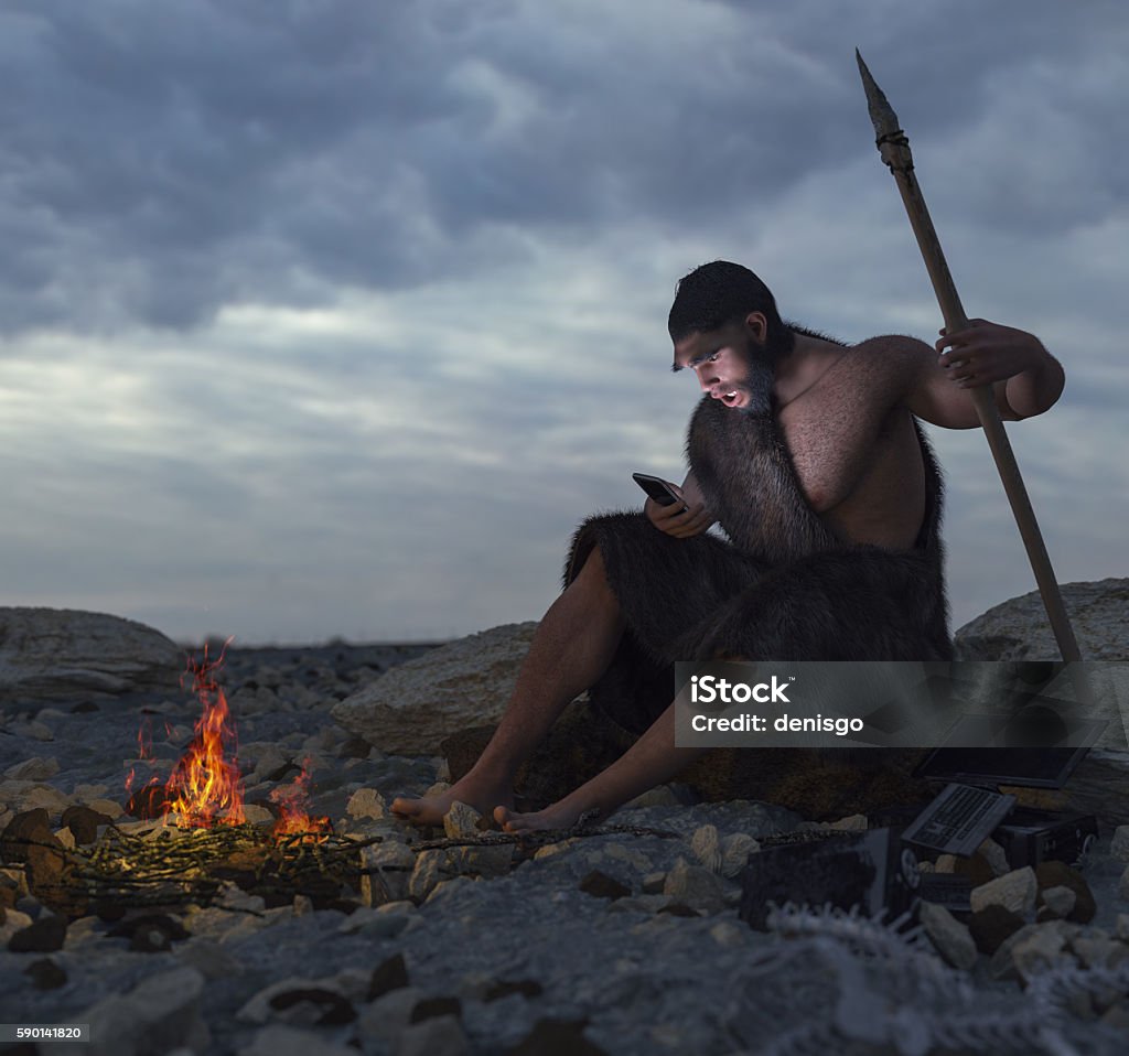 primitive man siting on the stone with smartphone Ancient Stock Photo