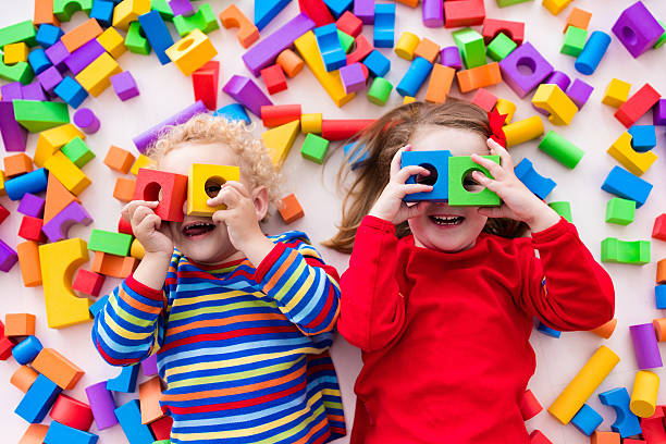 istock Funny children playing with colorful blocks. 590142876