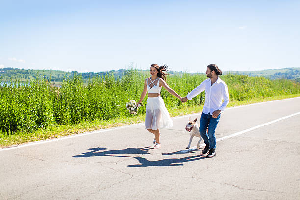 istock Bride and groom having fun with their dog 590143086