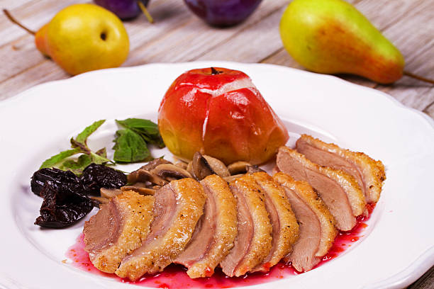 Baked duck fillet with spices and garnish. Pink sauce for poultry meat.