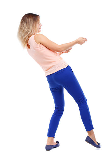 istock back view of standing girl pulling a rope from top 590144766