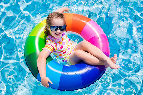 istock Child with colorful inflatable ring in swimming pool 590145022