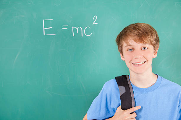 istock Pre-teenage student with math equation on school chalkboard. 590145986