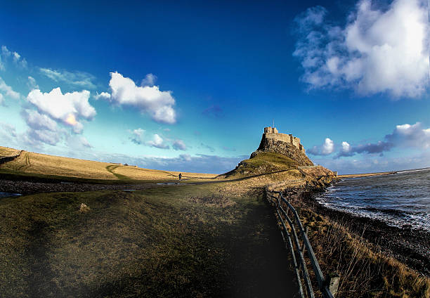 прогулка к замку - lindisfarne стоковые фото и изображения