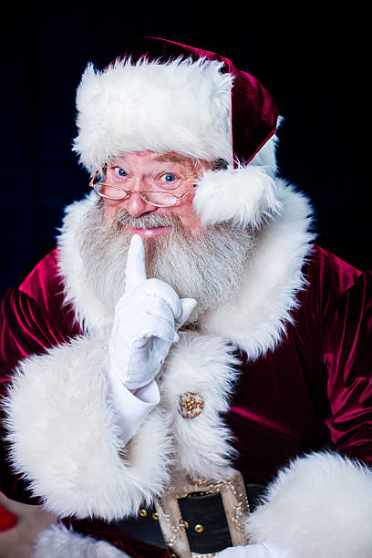 Santa Claus Portrait Santa Claus portrait on a dark background with Christmas Lights santa claus expressions shhh stock pictures, royalty-free photos & images