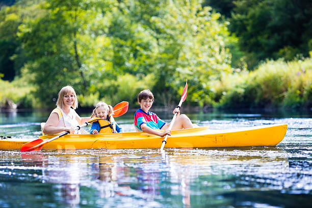 mãe com menina e menino adolescente curtindo passeio de caiaque - summer camp child teenager kayak - fotografias e filmes do acervo