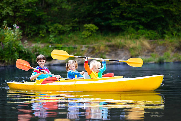 dzieci spływy kajakowe na rzece w upalny letni dzień - summer camp child teenager kayak zdjęcia i obrazy z banku zdjęć