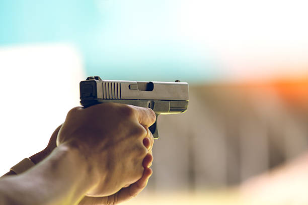 hand aim pistol in academy shooting range hand aim pistol in academy shooting range with flare and vintage color firing stock pictures, royalty-free photos & images