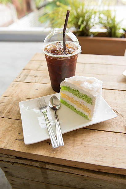 istock Ice coffee and coconut cake on wood table, 590151580