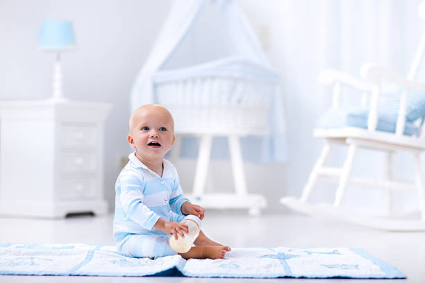 istock Little baby boy drinking milk in sunny nursery 590153096