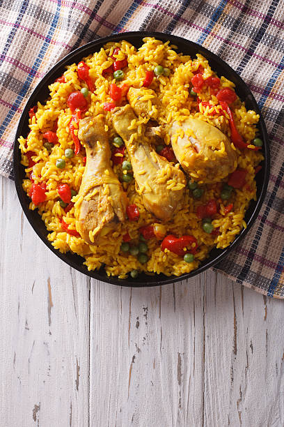istock Spanish paella with chicken and vegetables. vertical top view 590153806