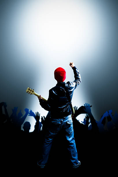 istock back of asian rocker playing guitar on stage 590154050