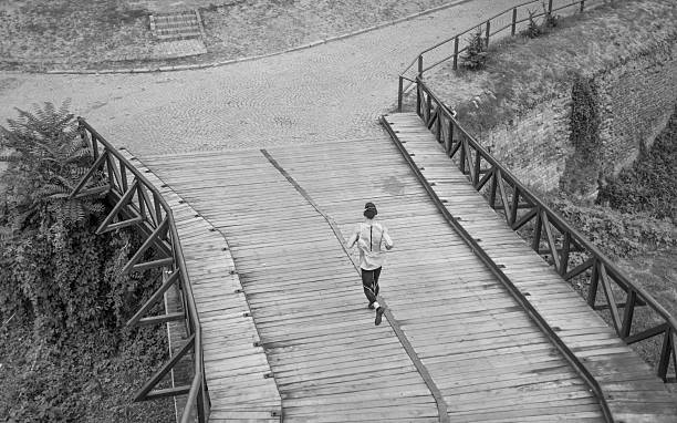 istock black and white one man run jogging elevated view rear 590154310