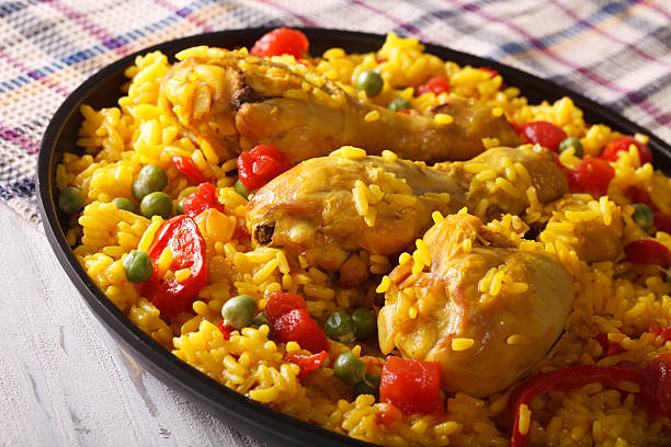 istock Paella with chicken drumsticks and vegetables close-up. horizontal 590154448