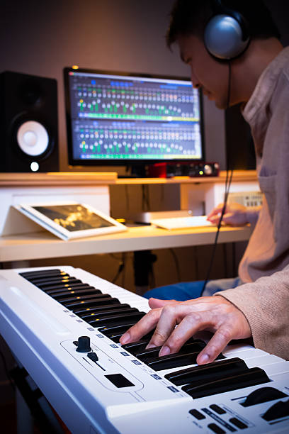 istock asian handsome musician composing song in recording studio 590155094