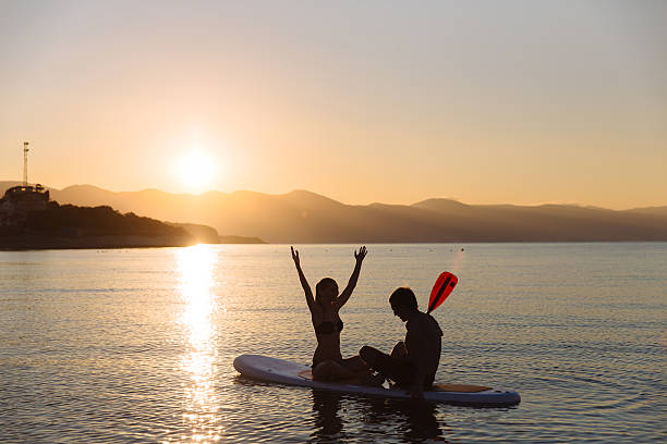 istock Silhouette of perfect couple engage standup paddle boarding 590156078