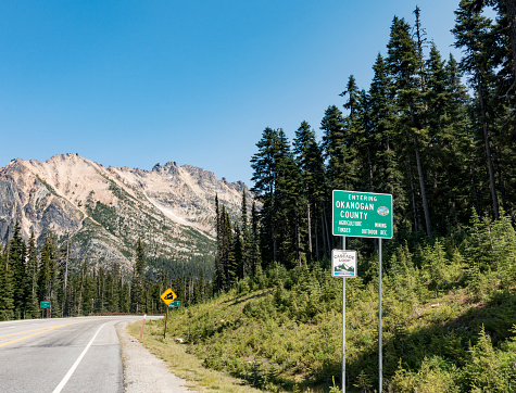 North Cascades, Washington, USA - July 30, 2016: Road Sign Entering Okanogan County Cascade Loop in Washington State