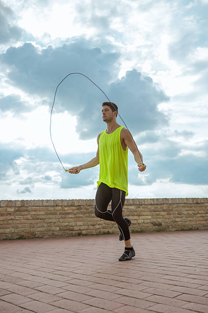 istock Young man jumping rope sky sunny 590156212