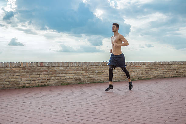 young man running jogging - shirtless men 20s adult imagens e fotografias de stock