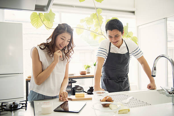 Young couple looking at the recipes in the digital tablet