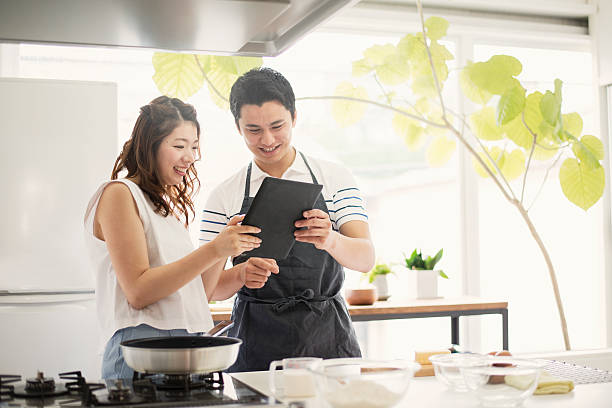Young couple looking at the recipes in the digital tablet