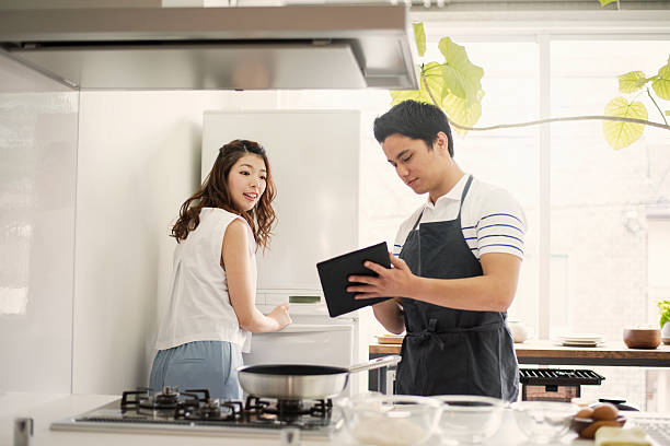 istock Young couple looking at the recipes in the digital tablet 590156706