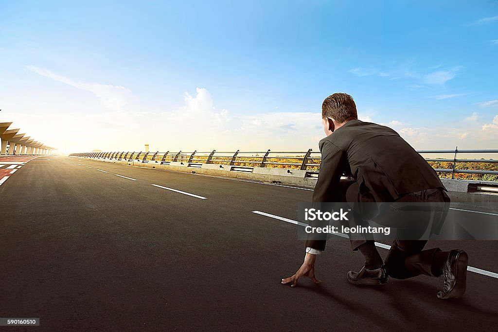 Asian business man ready to run Back view of asian business man ready to run on the street Beginnings Stock Photo