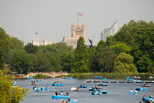 Summer in Hyde park A summer day in the Centre of London, the serpentine in Hyde park is busy with people on boats. The houses of parliament can be seen in the background. hyde park london photos stock pictures, royalty-free photos & images