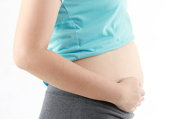 istock pregnant woman - isolated over a white background 590163192