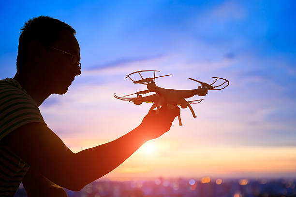 istock silhouette of man take drone 590164934
