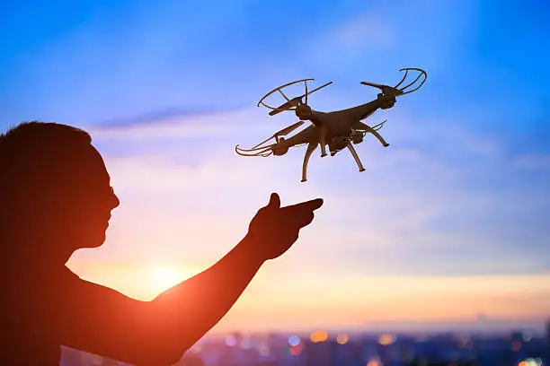 silhouette of man play drone in the sunset, asian