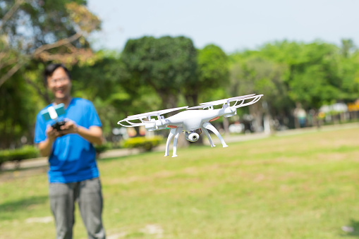 man play drone in the park happily, asian