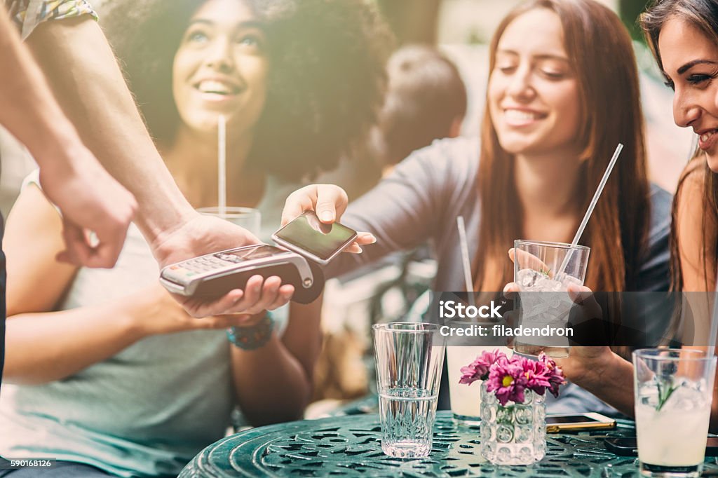 Contactless payment Woman paying contactless through a smart phone. Paying Stock Photo