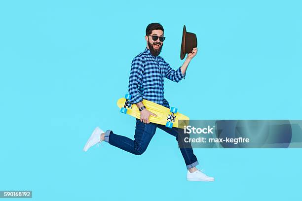 Pretty Young Bearded Man Jumping With Yellow Skateboard Stock Photo - Download Image Now