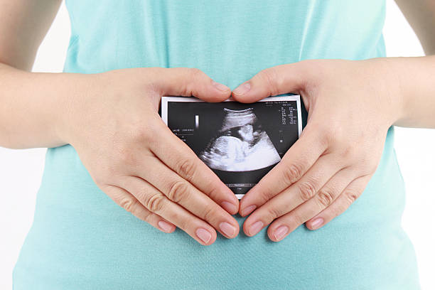 беременная женщина держит фотографию своего ультр�азвука - prenatal care стоковые фото и изображения