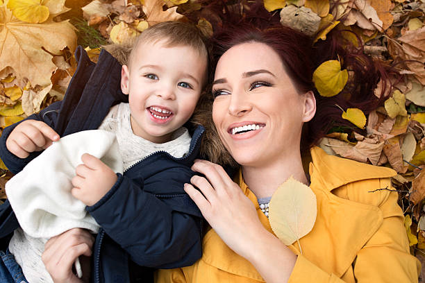 istock Funny mother and son lying on the leaves 590170226