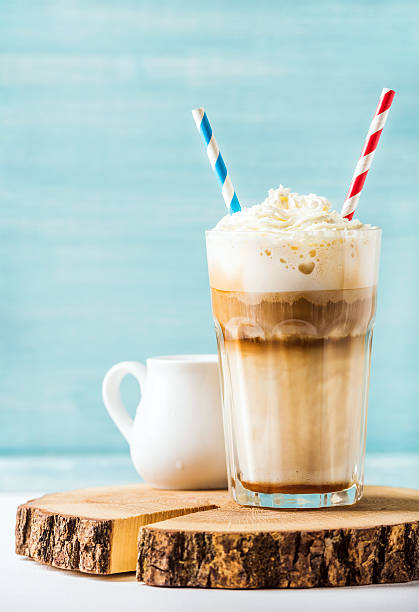 istock Latte macchiato with whipped cream in tall glass , two straws 590170704