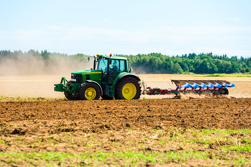 Kalmar, Sweden - August 10, 2016: Farmer using a John Deere 6930 while plowing a field after harvest.