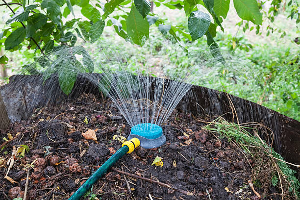 tas de compost d’humidification à l’aide d’un arroseur - tube messy dirty stack photos et images de collection