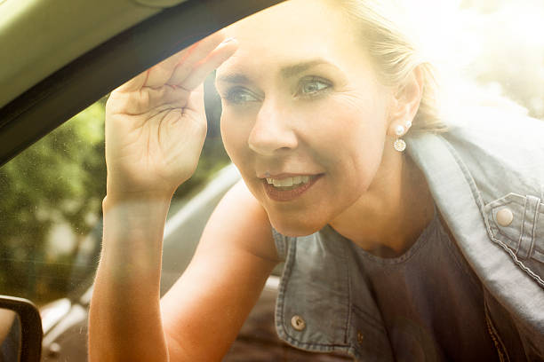 istock blond woman is looking inside a car 590172674