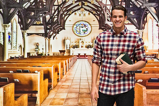 istock Smiling man standing in church 590173290