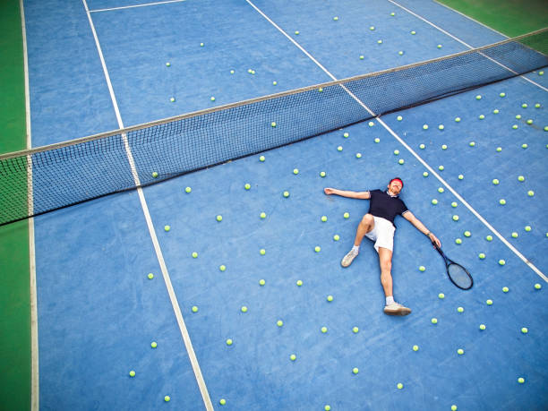 male tennis player lying on ground - tennis tennis ball sport court imagens e fotografias de stock