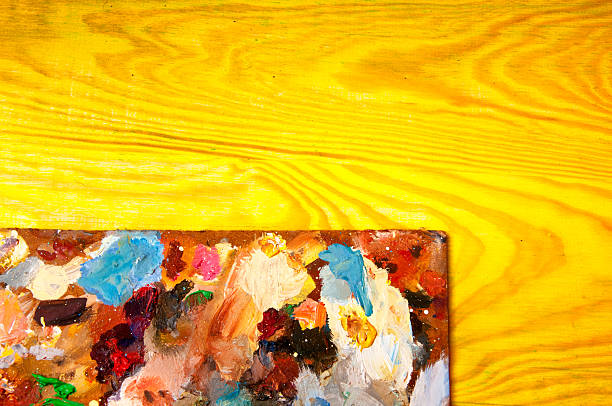 istock Painting palette on colored wooden background 590177768