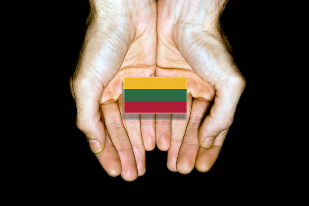 Flag of Lithuania in hands isolated on black background.