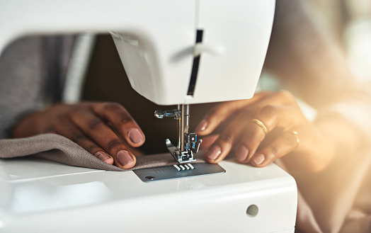 Cropped shot of a young fashion designer using a sewing machine in her workshop