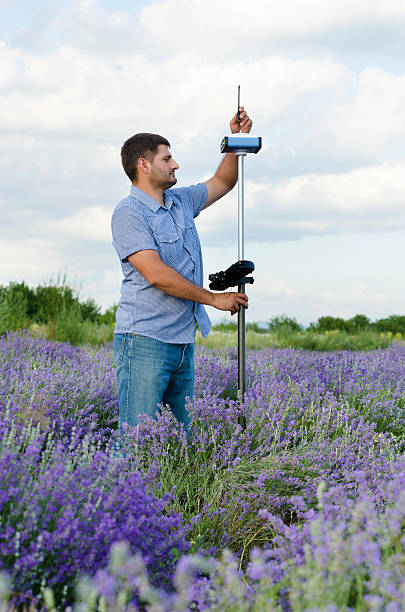 istock Land surveyor tracing in a lavenerd field 590182118