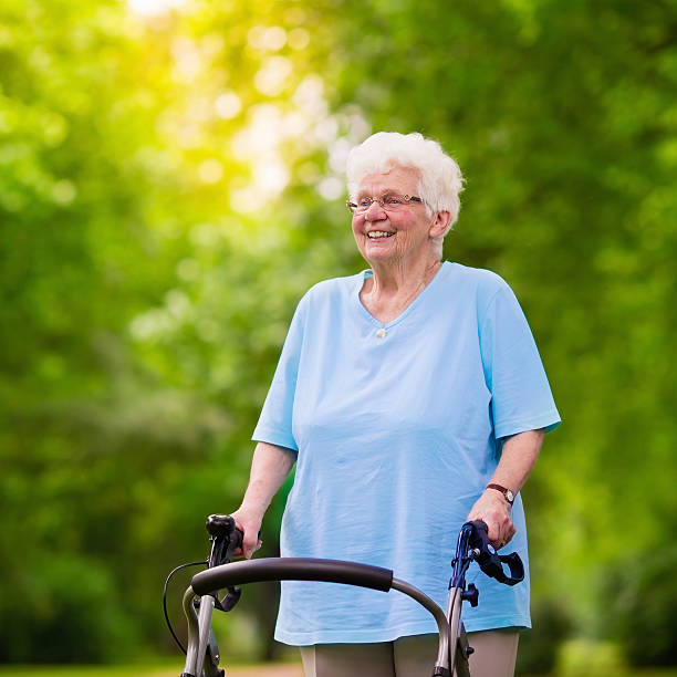 istock Senior lady with a walker enjoying a walk 590240714